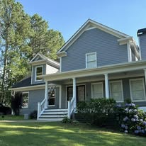 Blue-gray sided home with white trim and front porch