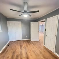 Freshly painted bedroom with new flooring and ceiling fan
