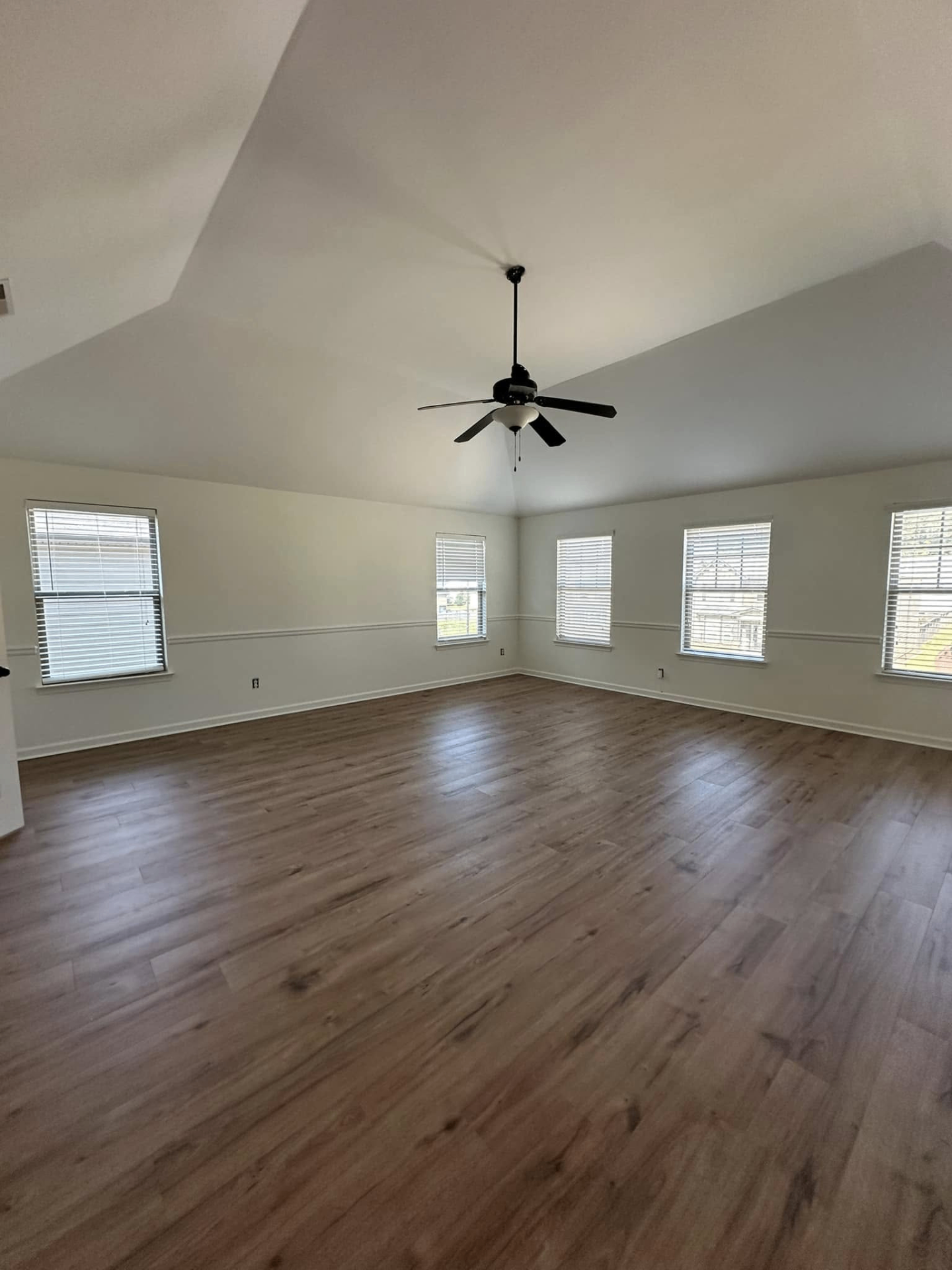 Bright living room with vaulted ceiling and new flooring